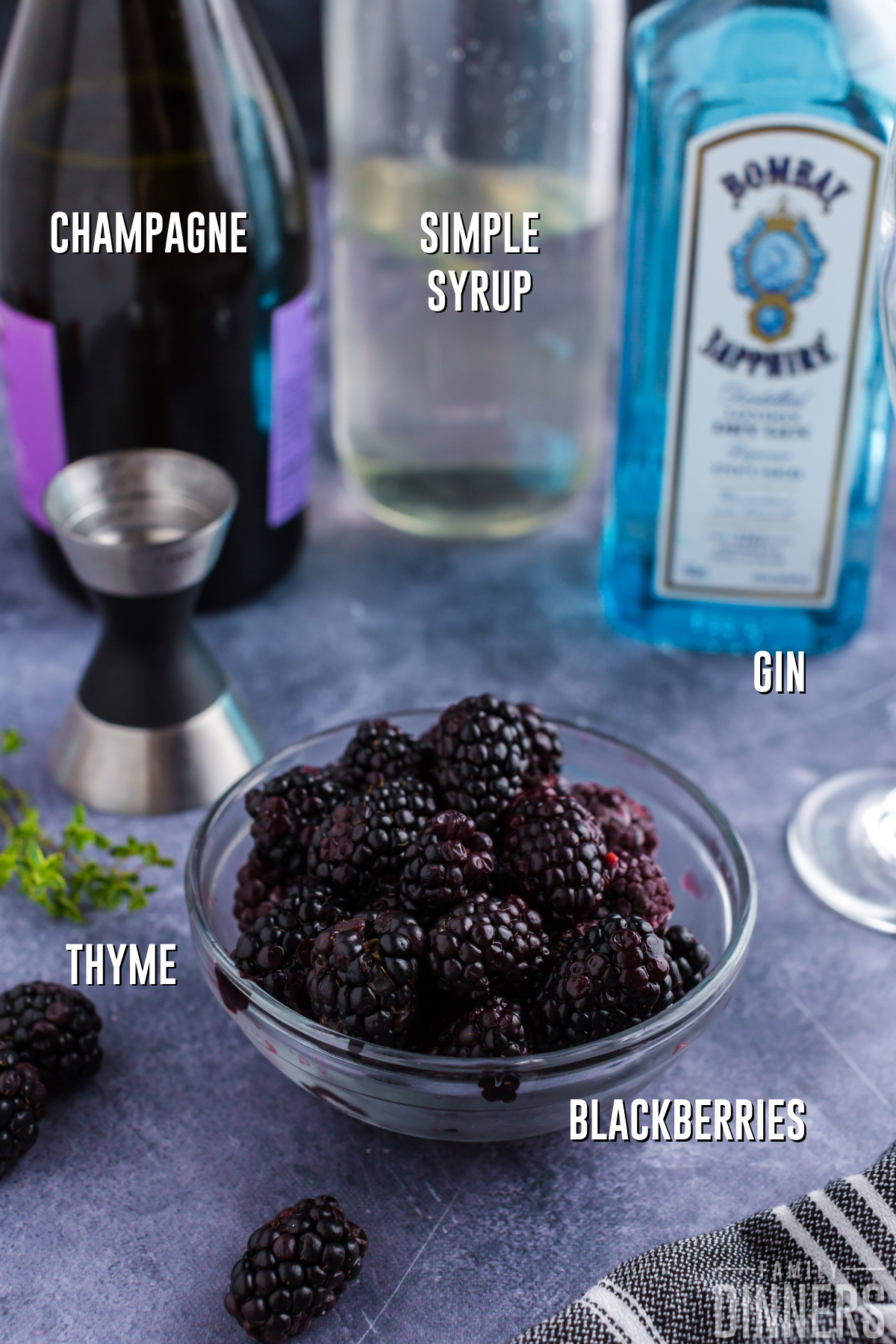 ingredients for blackberry gin cocktail in bowls on a dark gray counter
