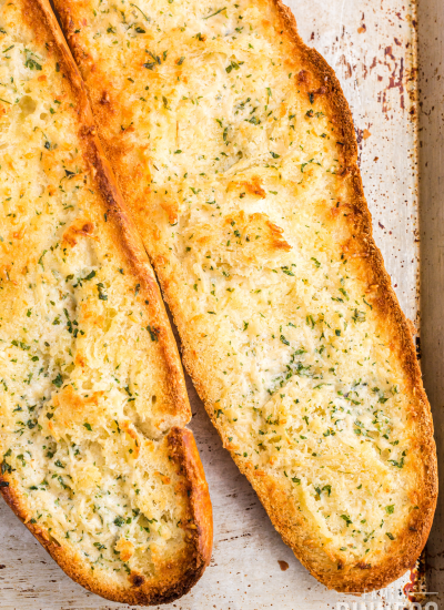 2 halves of a french bread open and toasted with garlic and parmesan