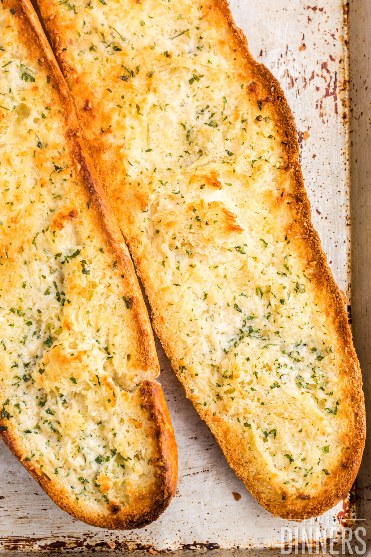 2 halves of a french bread open and toasted with garlic and parmesan