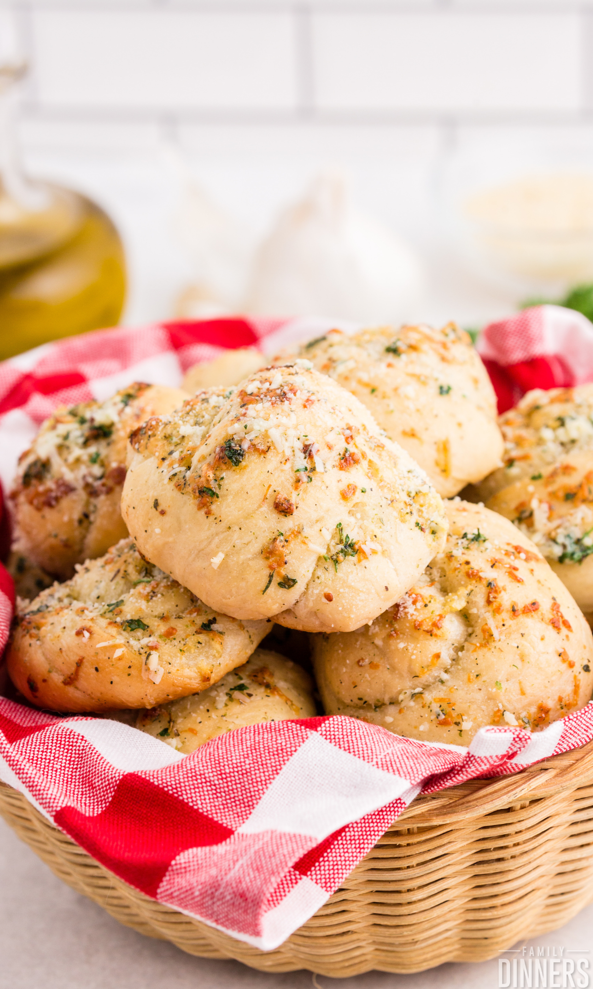 pizza dough garlic knots in a basket with red and white checkered cloth