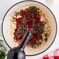 wine pouring into pot for spaghetti marinara sauce recipe
