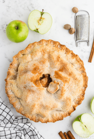 apple pie with a golden pie crust on white counter