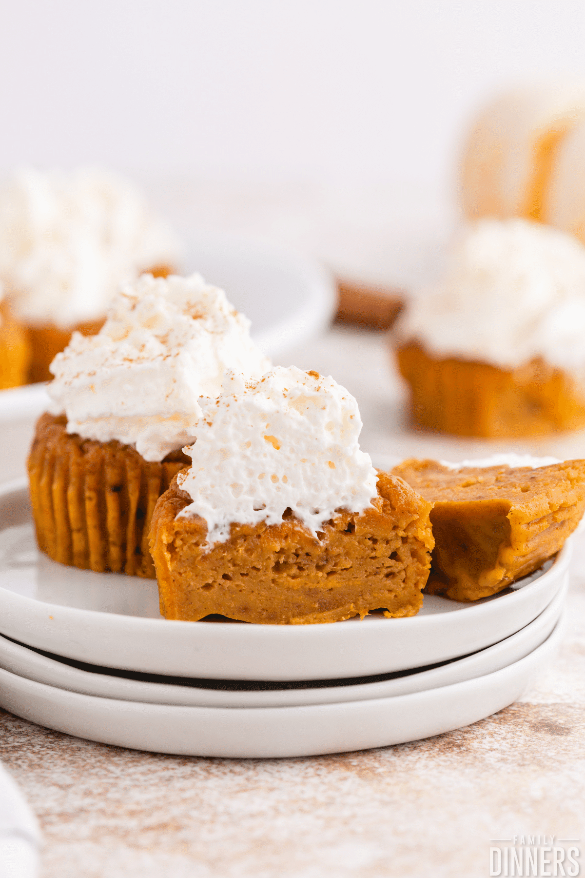 pumpkin pie cupcakes on white plate with whipped cream