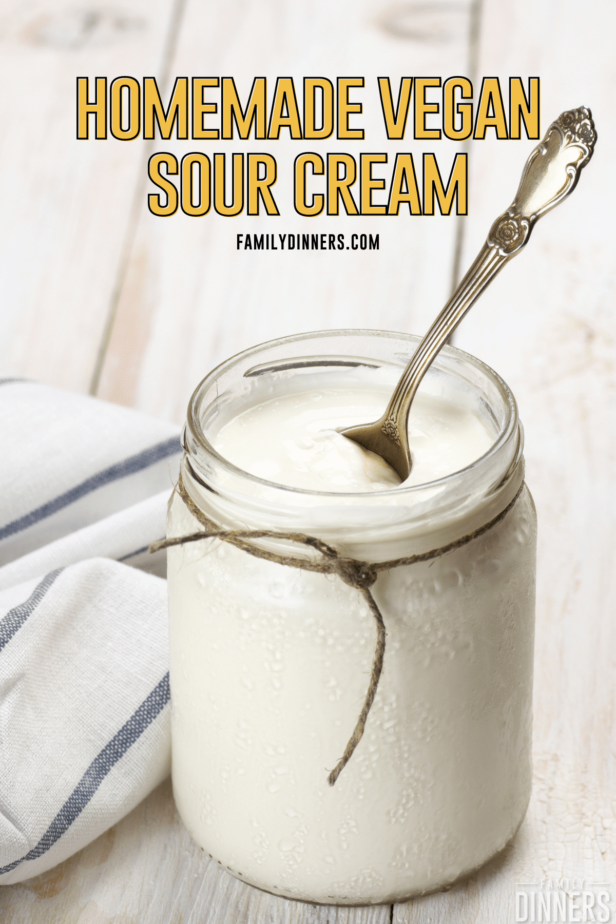 homemade vegan sour cream in a glass jar on white washed wood board