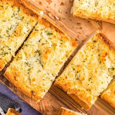 recommended recipe: garlic french bread golden roasted on wood cutting board
