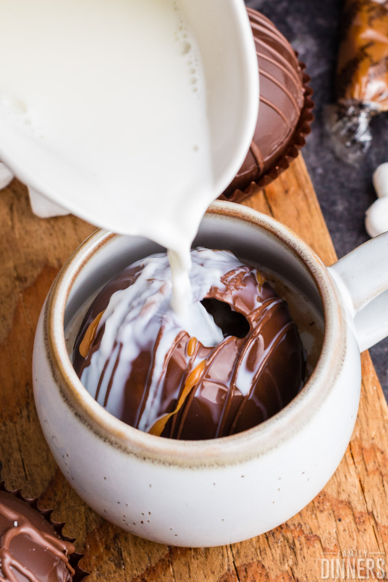 Milk pouring over a salted caramel hot chocolate bomb.