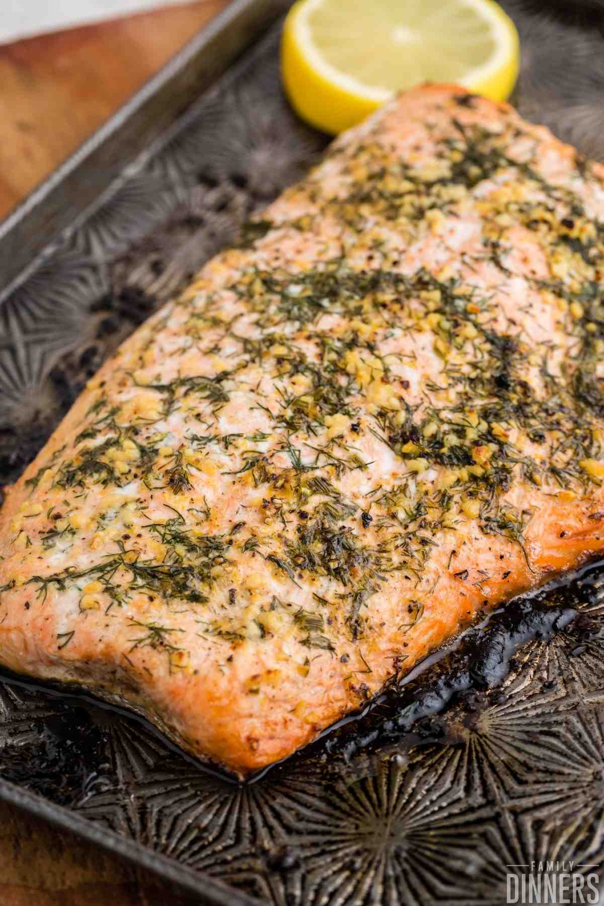 baked salmon with lemon dill butter being flaked with a fork