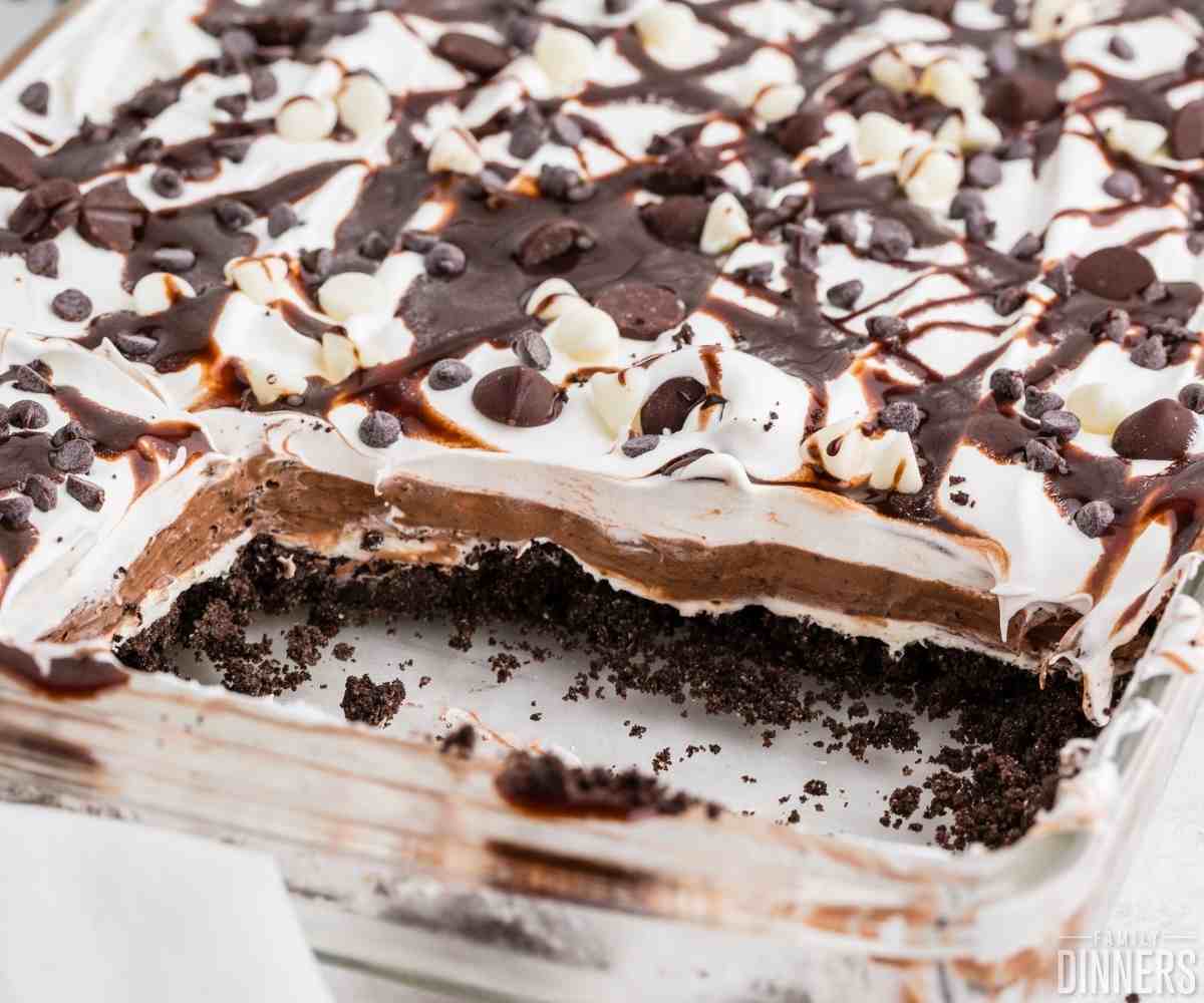 close up of chocolate lasagna in a baking dish with some taken out and exposing the layers