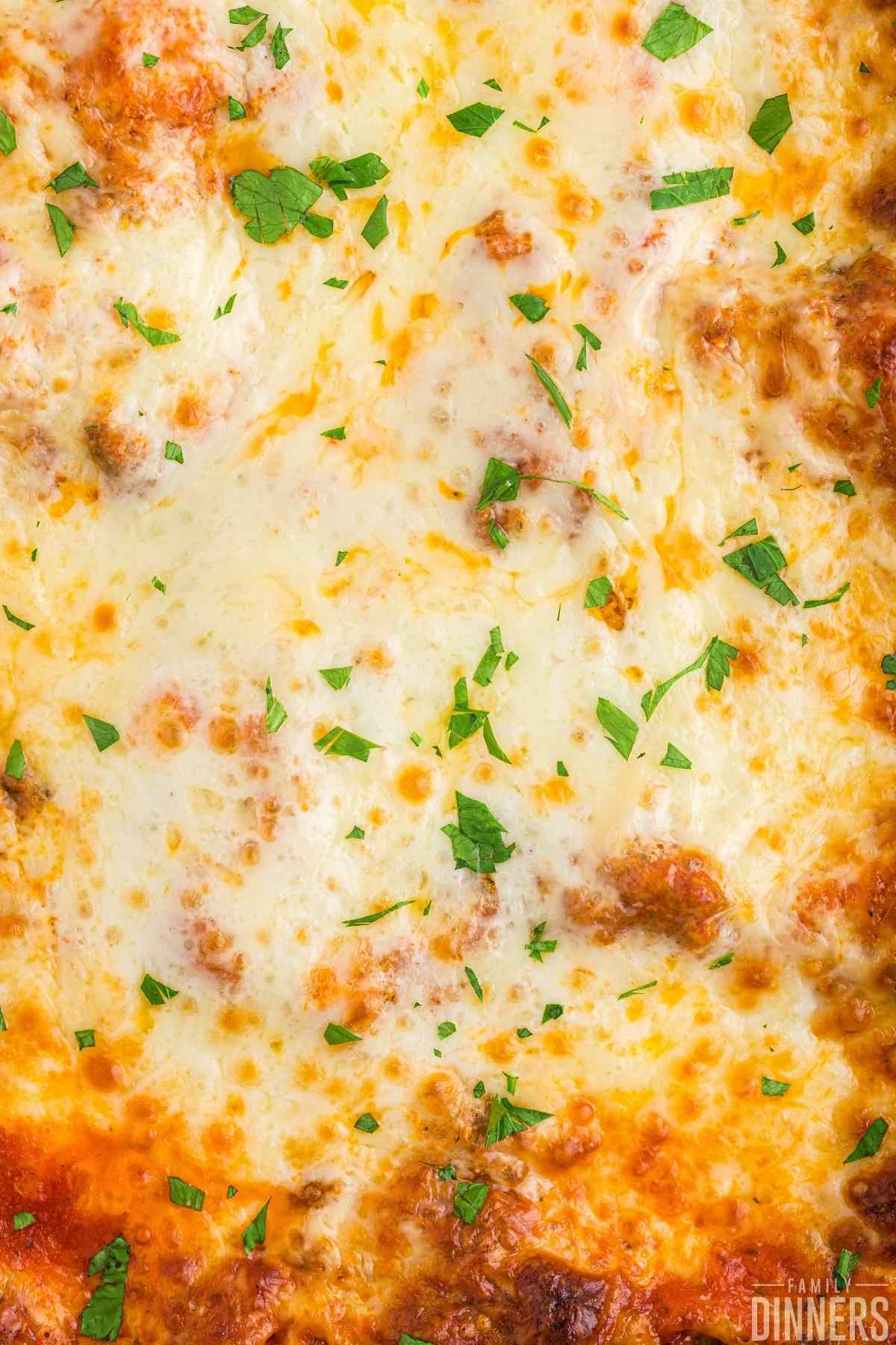 close up of baked cheese on top of lasagna
