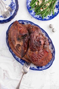 caramelized and perfectly browned spiral ham with a brown sugar glaze. Side dish of green beans with almonds.