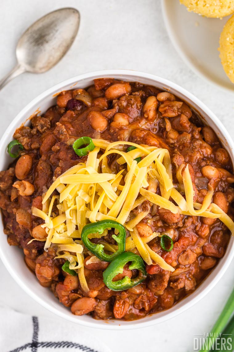 Bowl of chili with cheese and jalapenos on top.