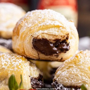 Stack of mini chocolate filled pasty puffs with powdered sugar on top