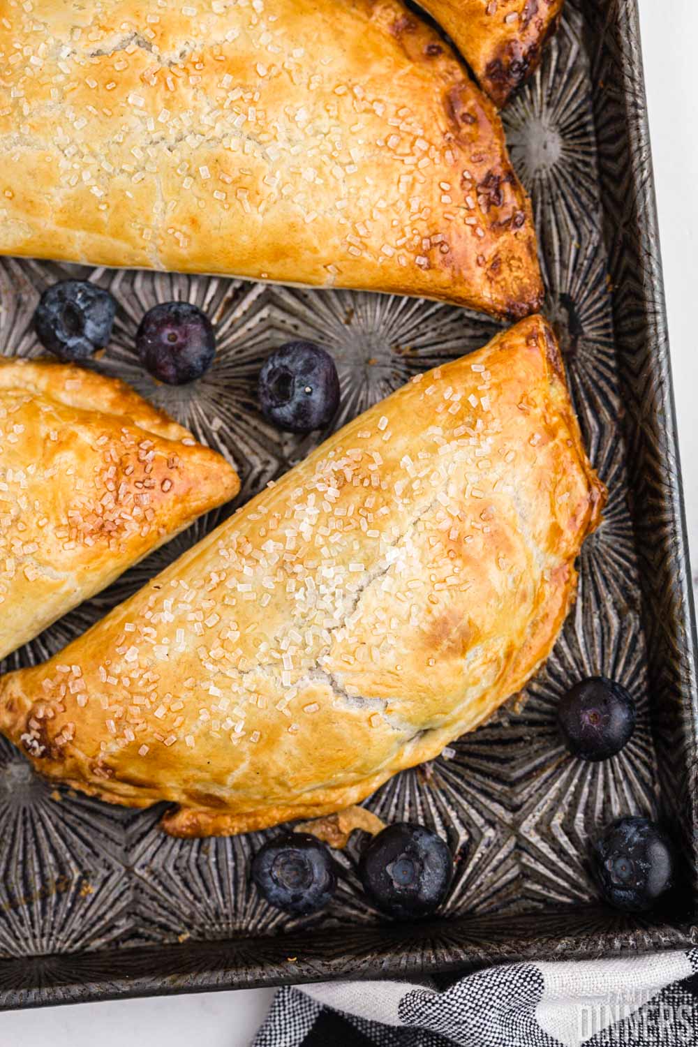 blueberry hand pies on a pretty metal sheet pan