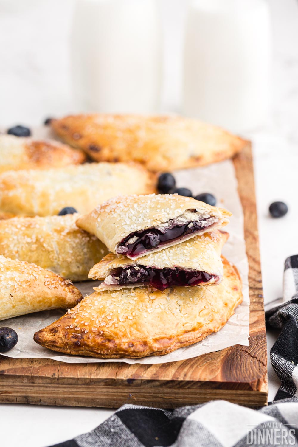 stack of blueberry hand pies on a wood board.