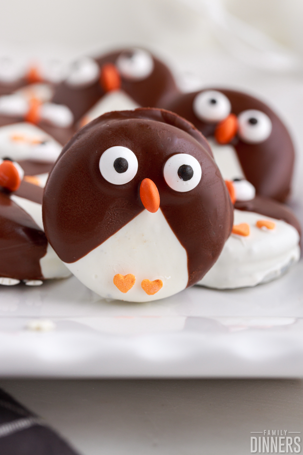 penguin cookie standing up on cake stand