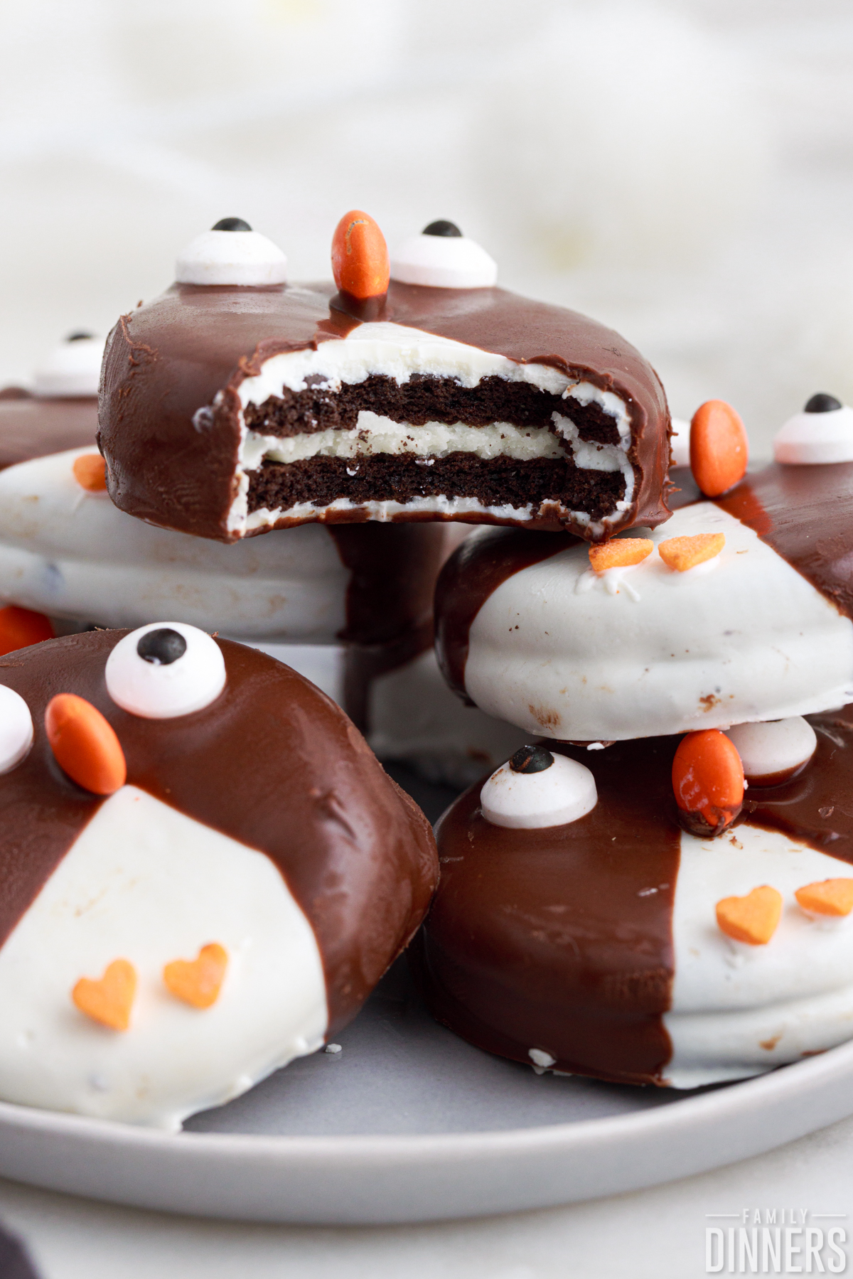 stack of penguin decorated cookies. Top cookie has a bite out of it.