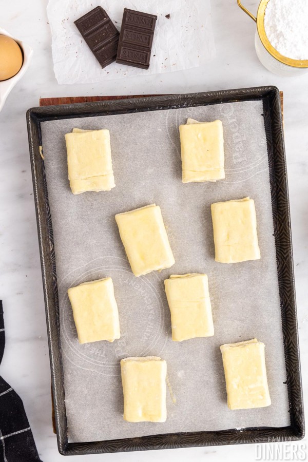 8 mini uncooked puff pastries on a baking sheet