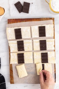 hand folding puff pastry over chocolate