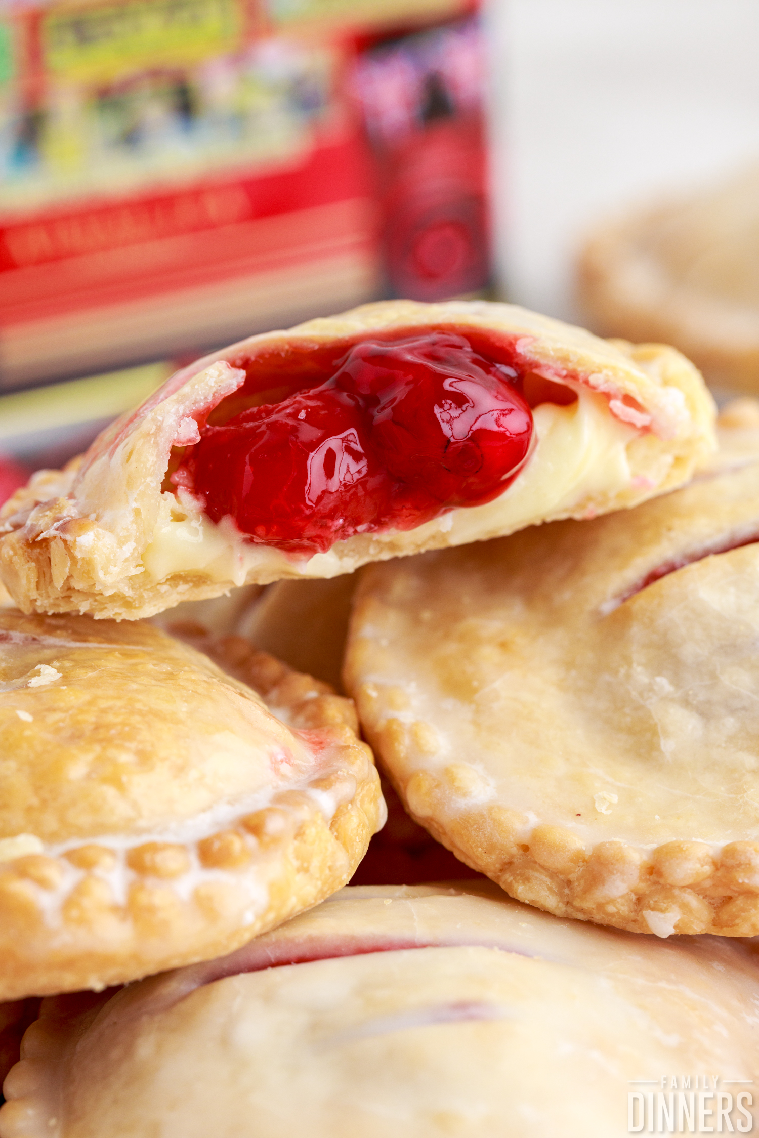 freshly baked cherry cheesecake hand pies, one with the filling coming out