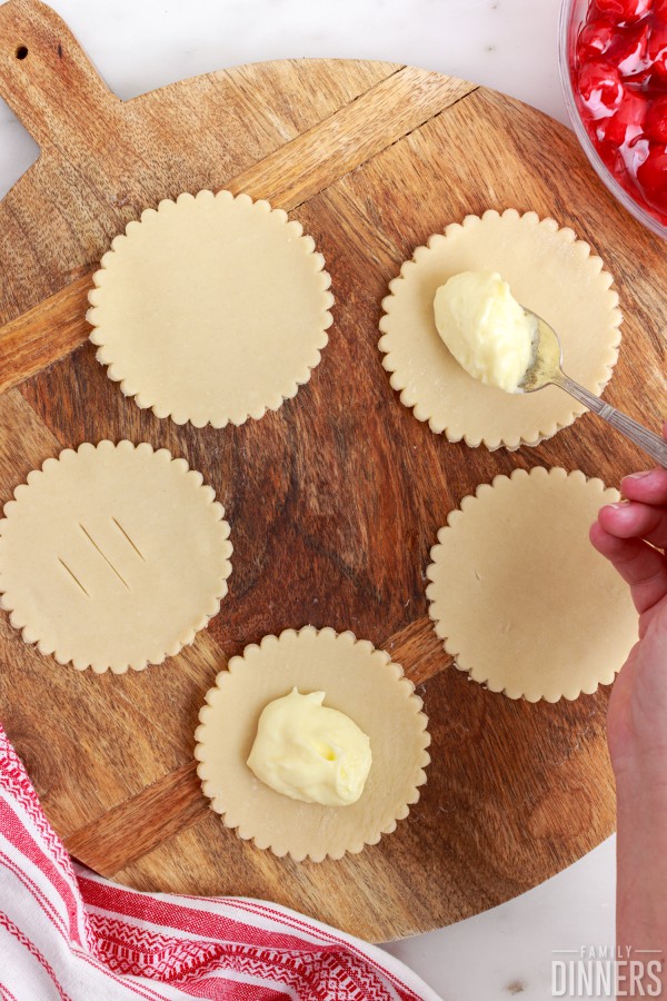 spoonful of cream cheese mixture on pie crust rounds