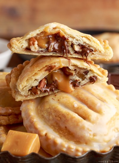 stacked turtle hand pies that are broken open with chocolate and caramel oozing out