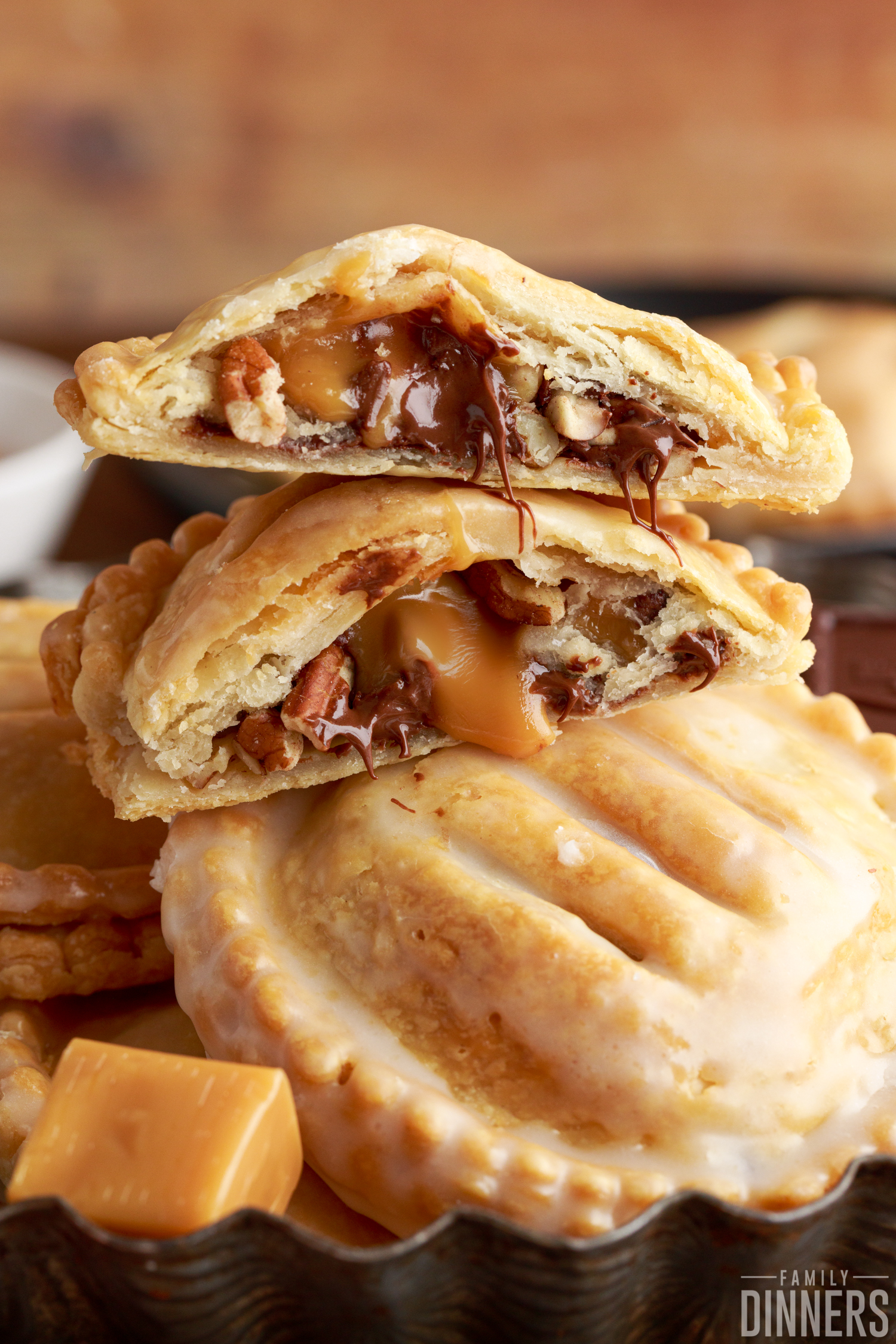 stacked turtle hand pies that are broken open with chocolate and caramel oozing out