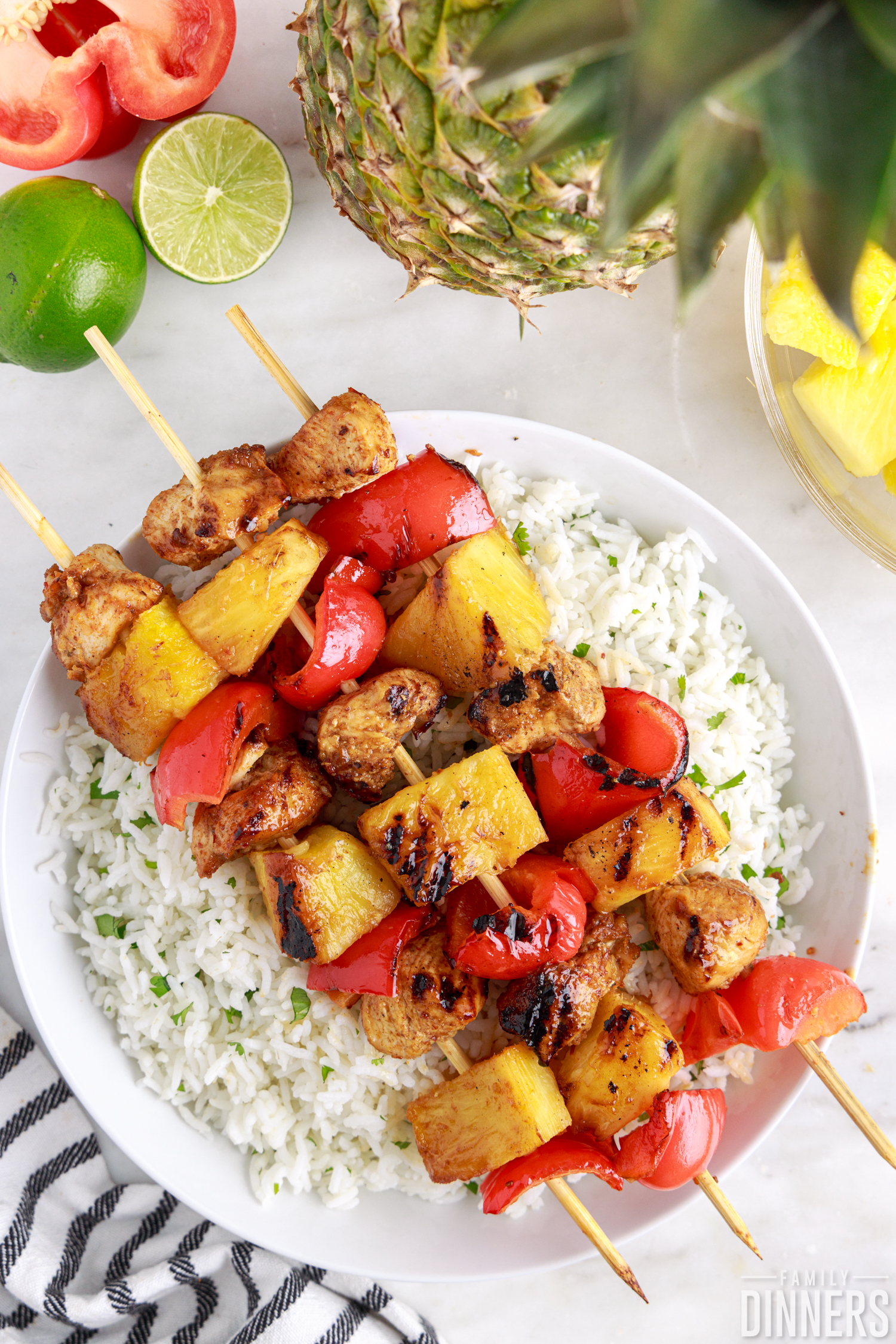 three chicken kabobs resting on a bowl of cilantro lime rice