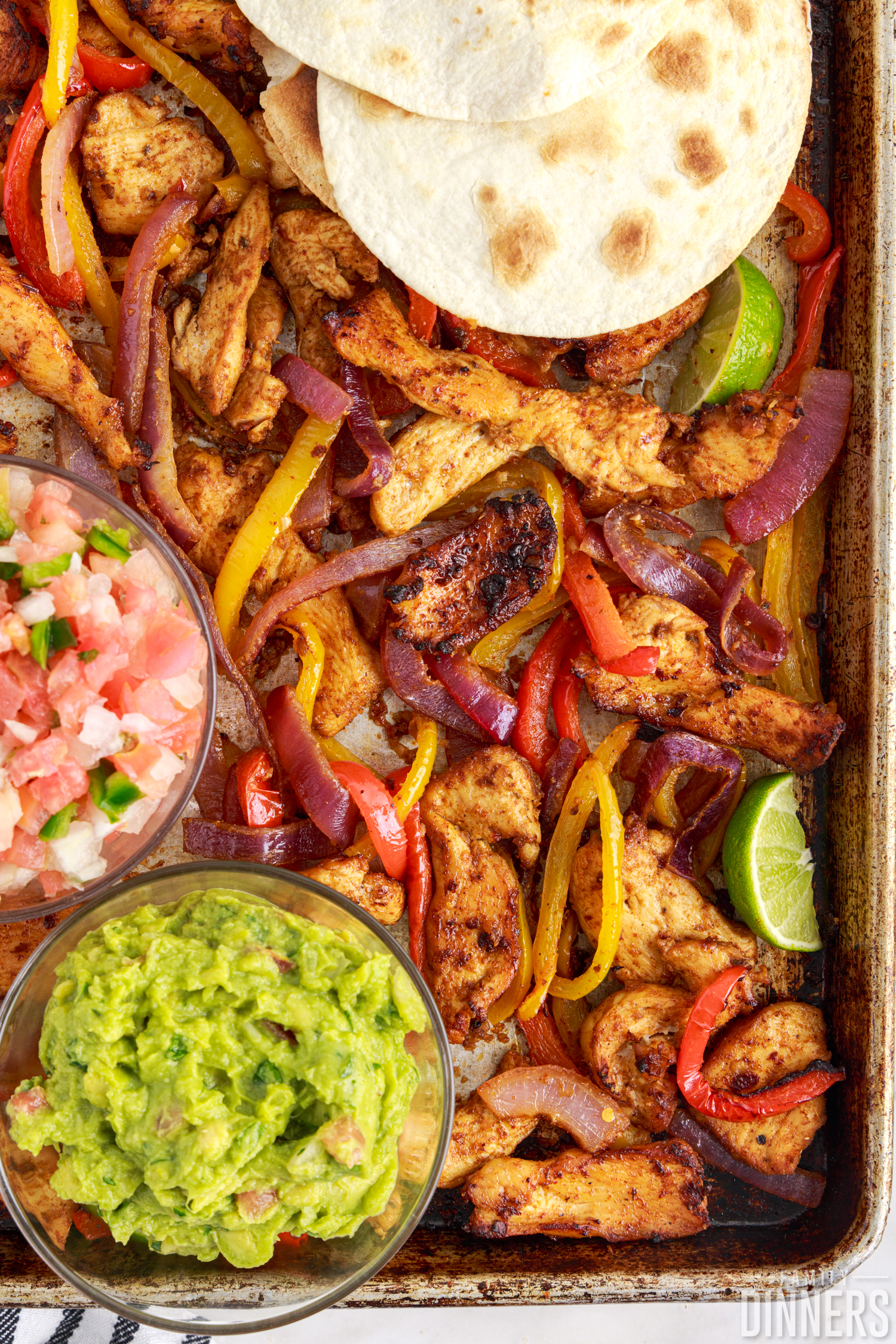 chipotle chicken sheet pan fajitas with guacamole, salsa and tortillas