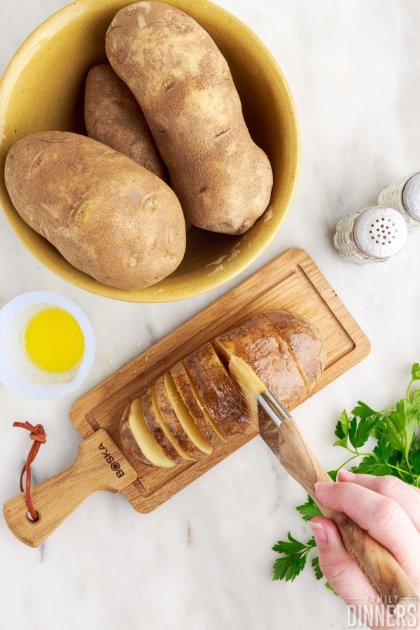 basting brush brushing butter into cut slots of potato