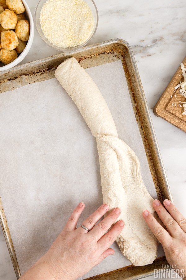 hand rolling out french bread dough