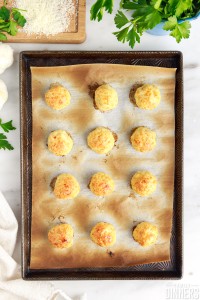 3 rows of 4 cooked chicken meatballs on a baking sheet