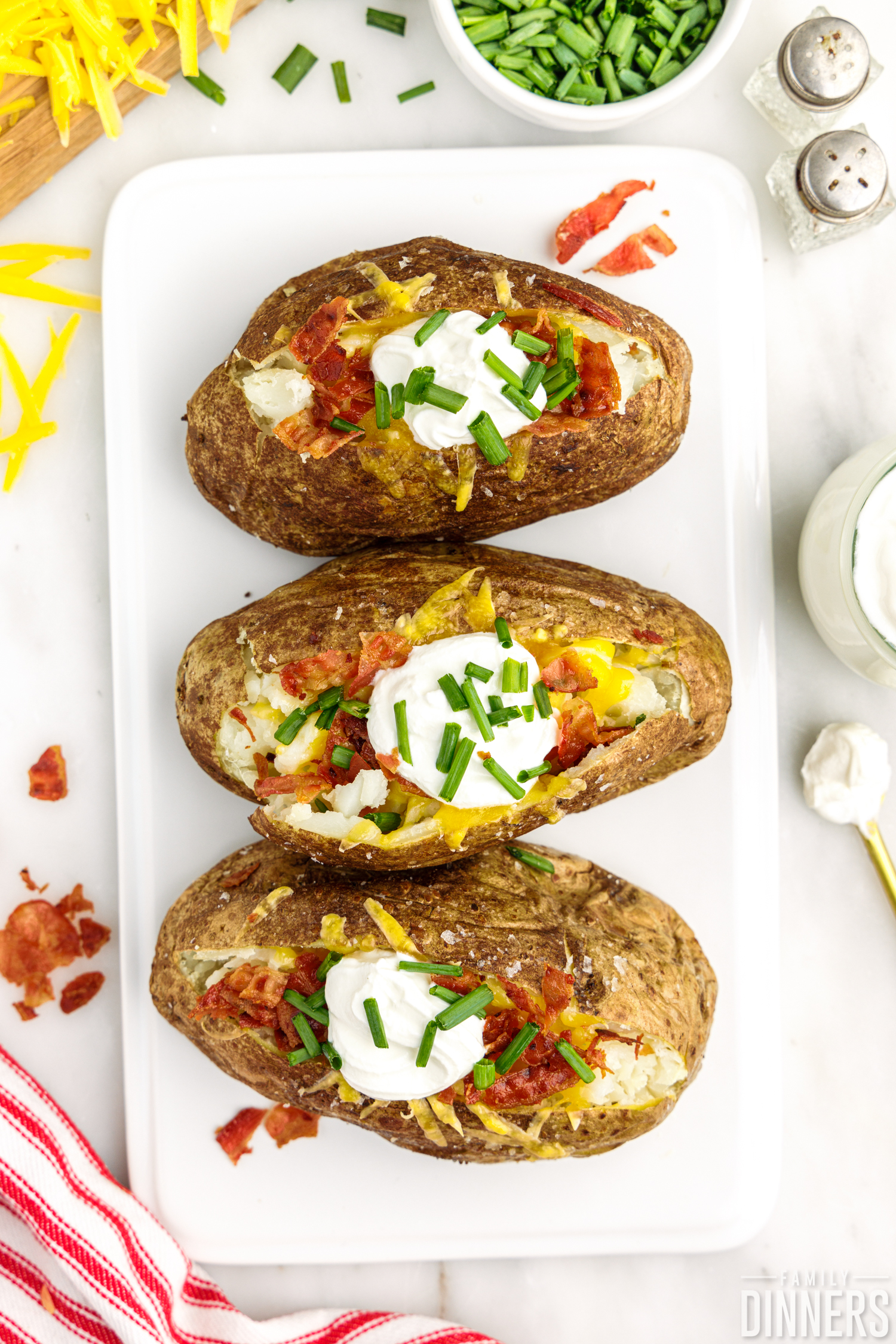 cooked potatoes with toppings on a white board