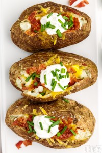 A row of fully loaded baked potatoes.