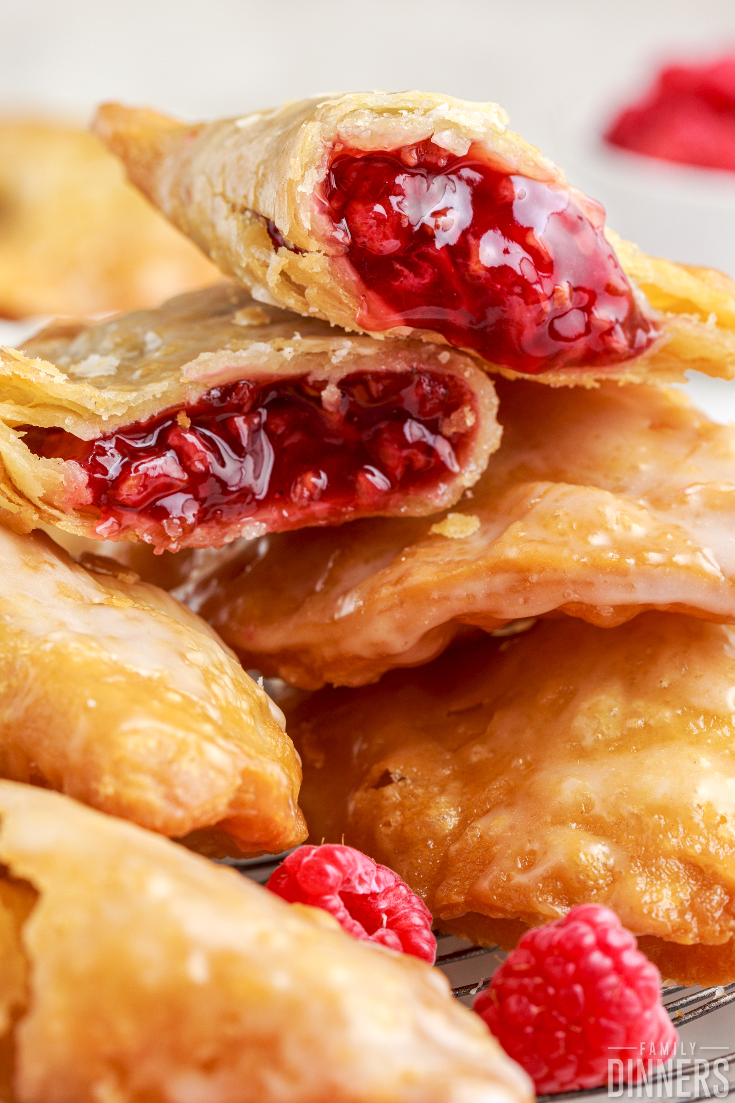 stack of raspberry hand pies, one is cut open to show the filling