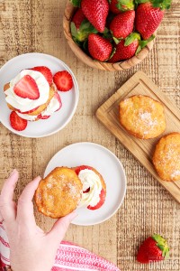 deep fried biscuit being put on top of strawberry and whipped cream