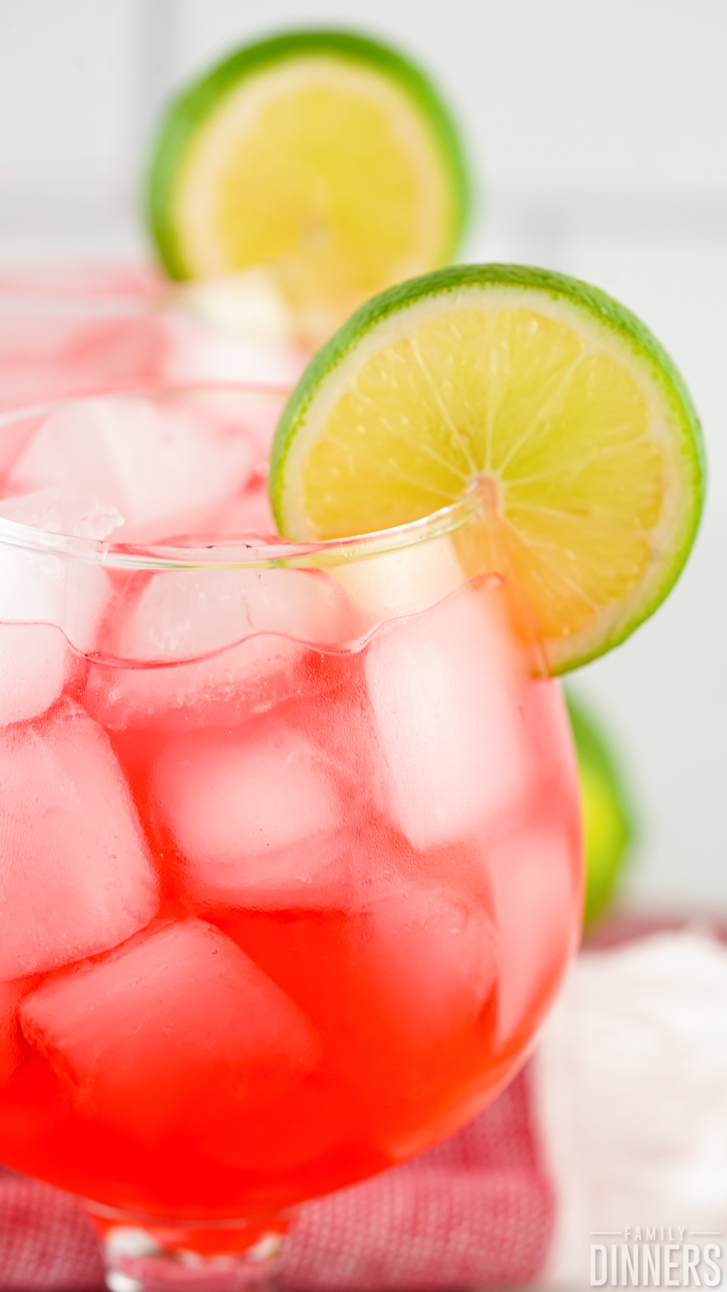 close-up of a Dirty Shirley drink with ice cubes and a lime slice on the rim of the glass