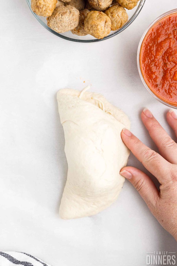 pizza crust folded in half over toppings