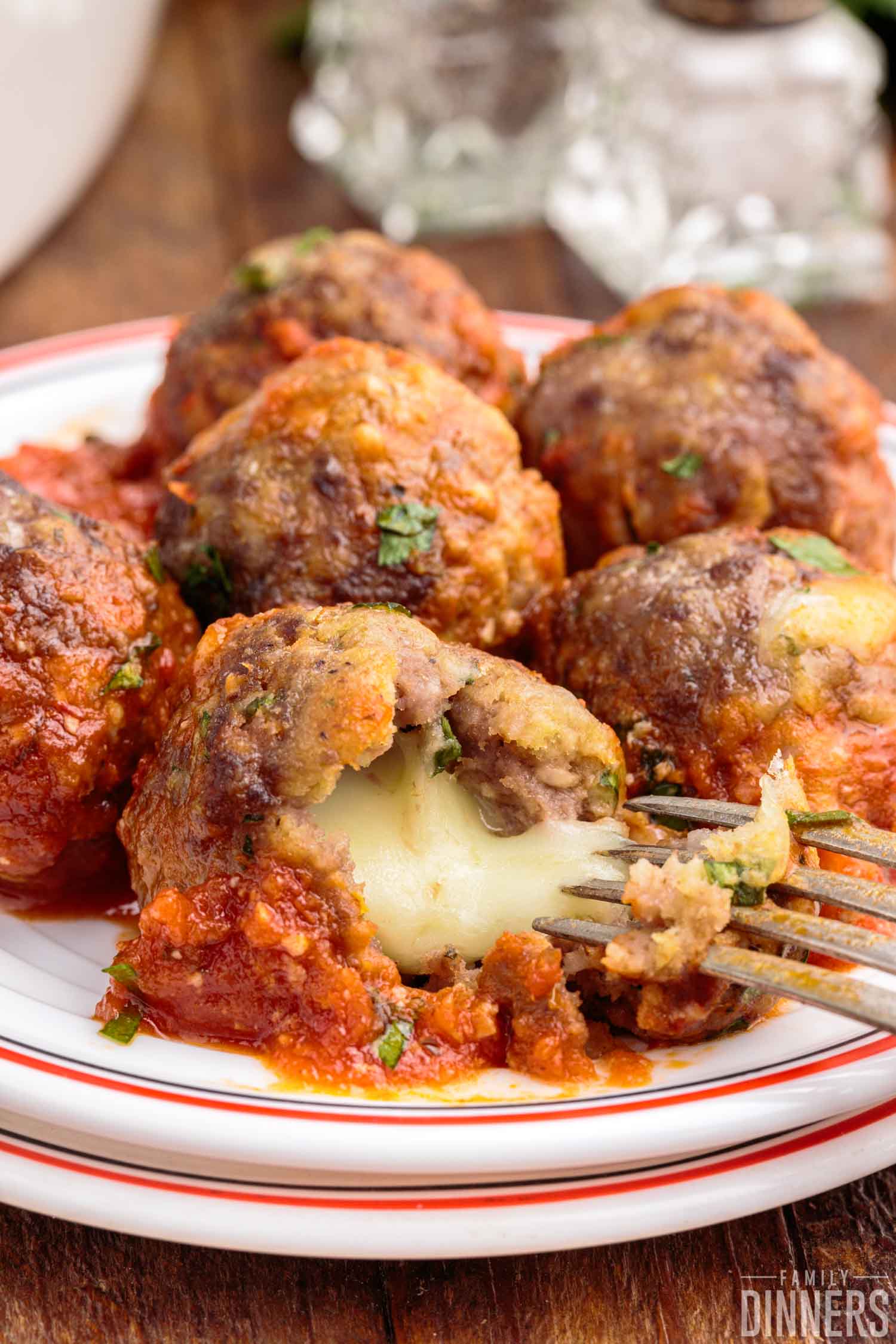 cheesy stuffed meatballs with one cut open 