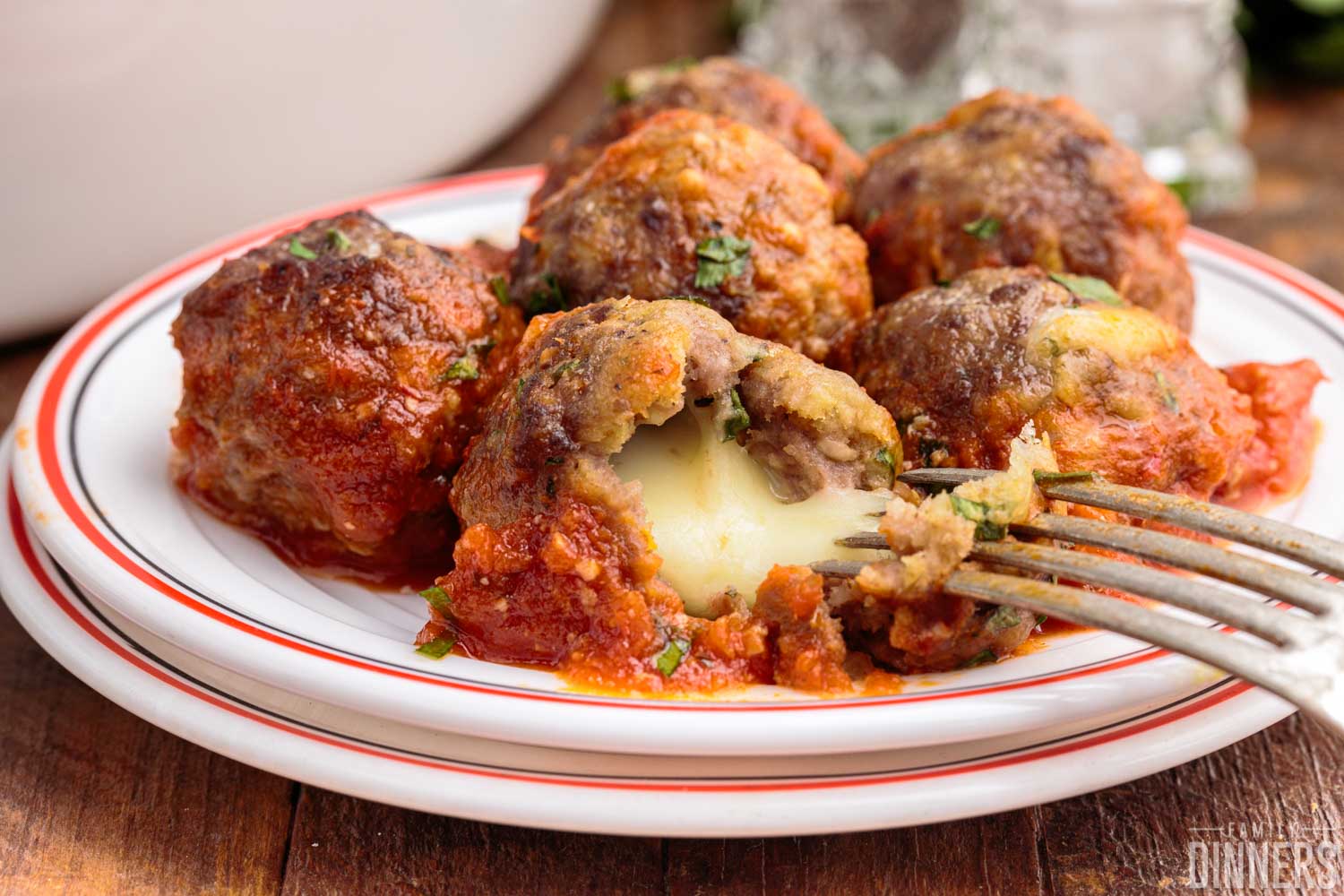 cheese stuffed meatballs on a plate with tomato sauce