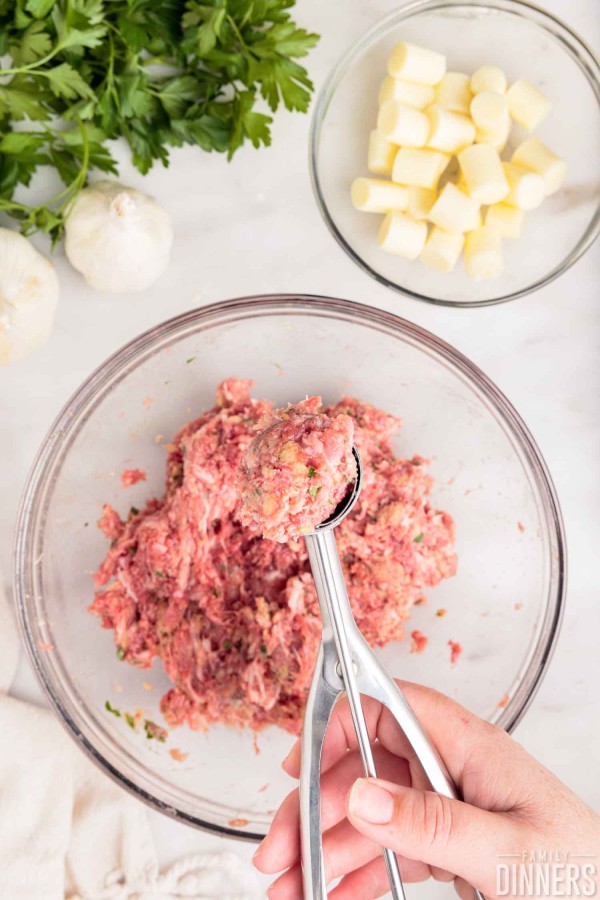 cookie scooper full of meatball mixture