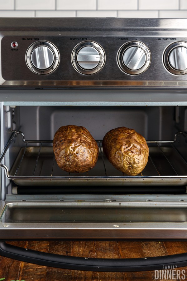 Two baked potatoes in the toaster oven.