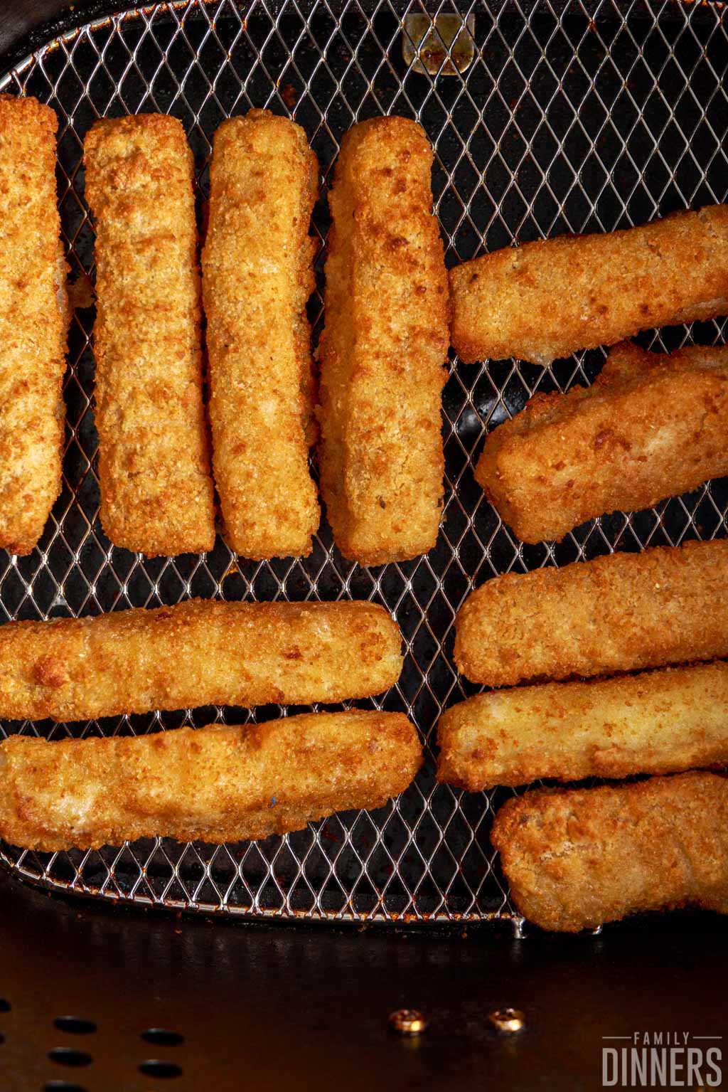 close up of cooked fish sticks in the air fryer