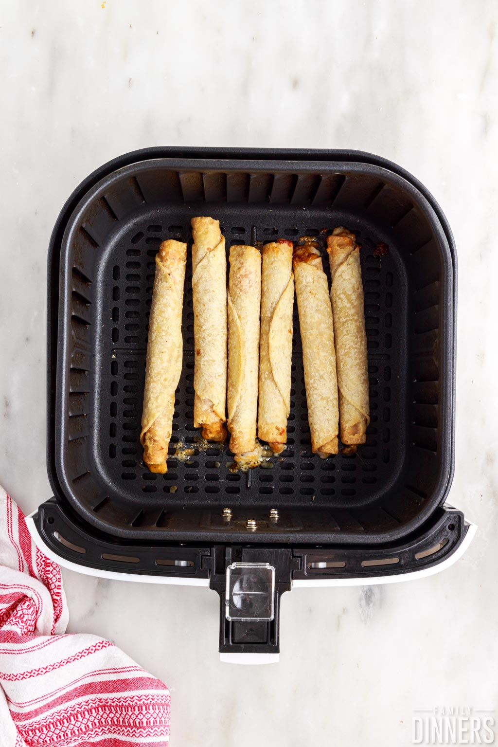 Cooked taquitos in an air fryer.