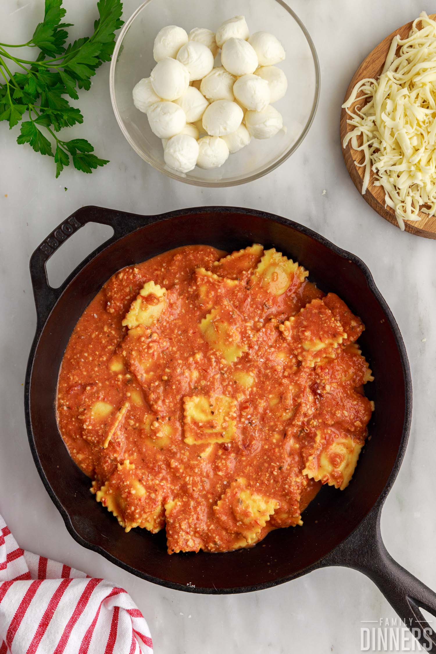 Ravioli and sauce in a cast iron pan.