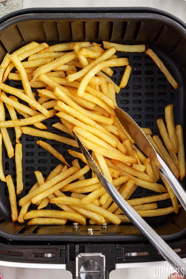 air fryer frozen french fries cooked in air fryer basket.