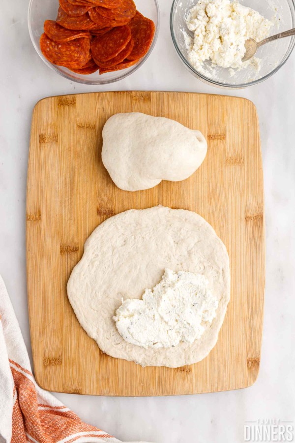 Ricotta mixture spooned onto pizza dough.