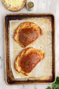 cooked calzones on baking sheet.