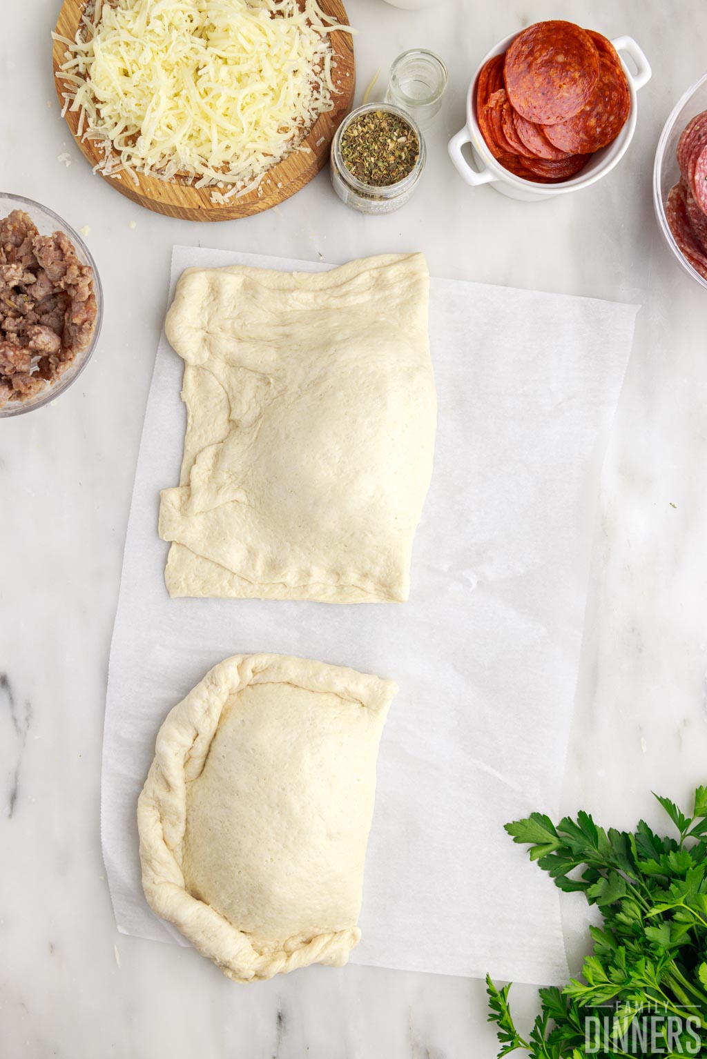 Calzone dough with filling folded over and pinched into pockets.