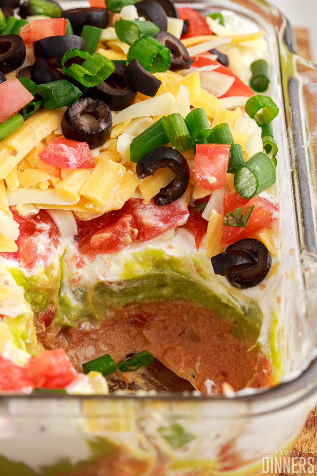 7 layer dip in pan with a missing scoop.