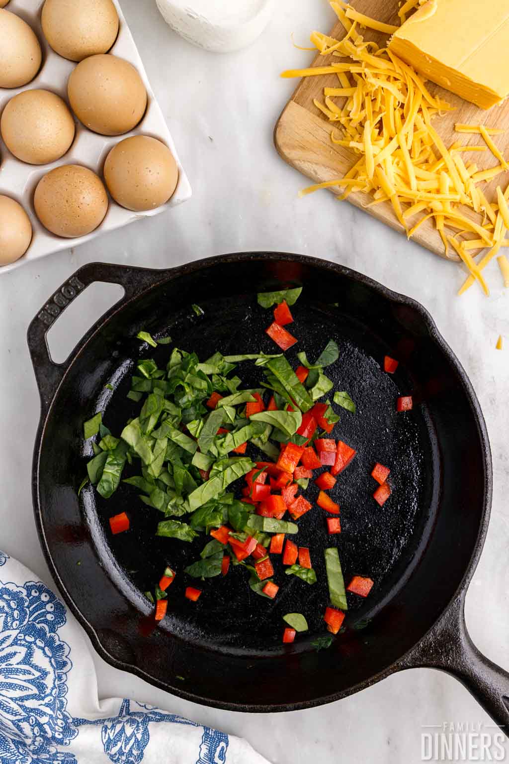 Peppers and spinach in a cast iron pan.